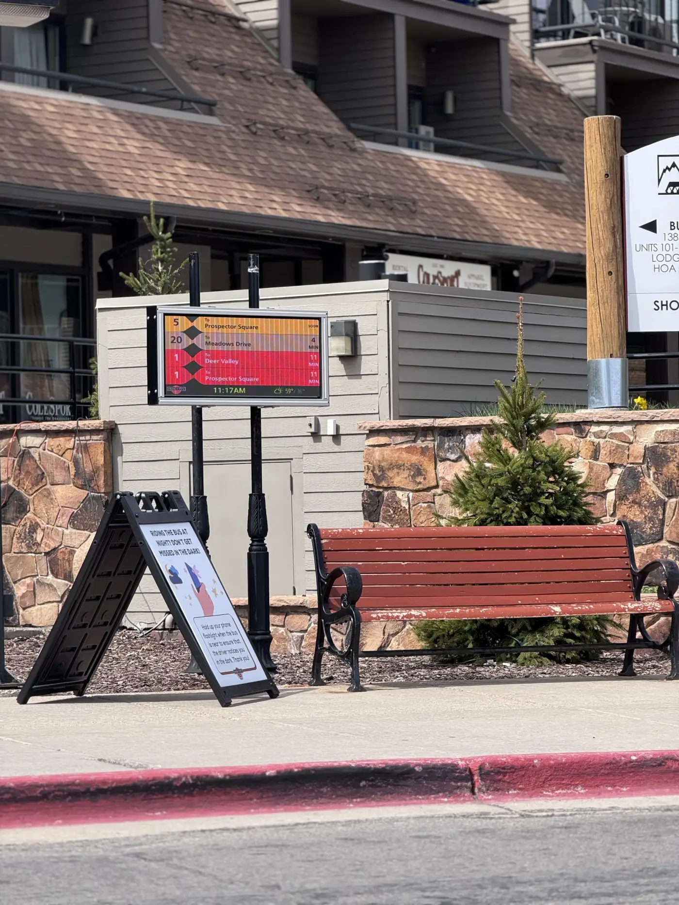 Wayside arrivals display beside a bench at a village stop